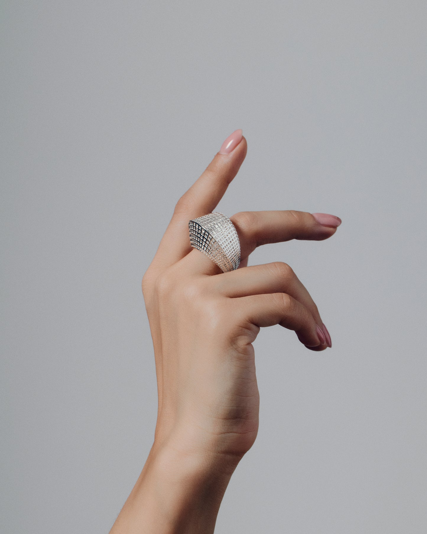 Gold open-work grid ring with a sculptural geometric pattern and bold rounded band. This chunky gold statement ring features a modern lattice texture that gives it depth and dimension while remaining lightweight and comfortable. Crafted in polished gold-tone metal, it adds a refined, architectural edge to everyday or occasion wear.
