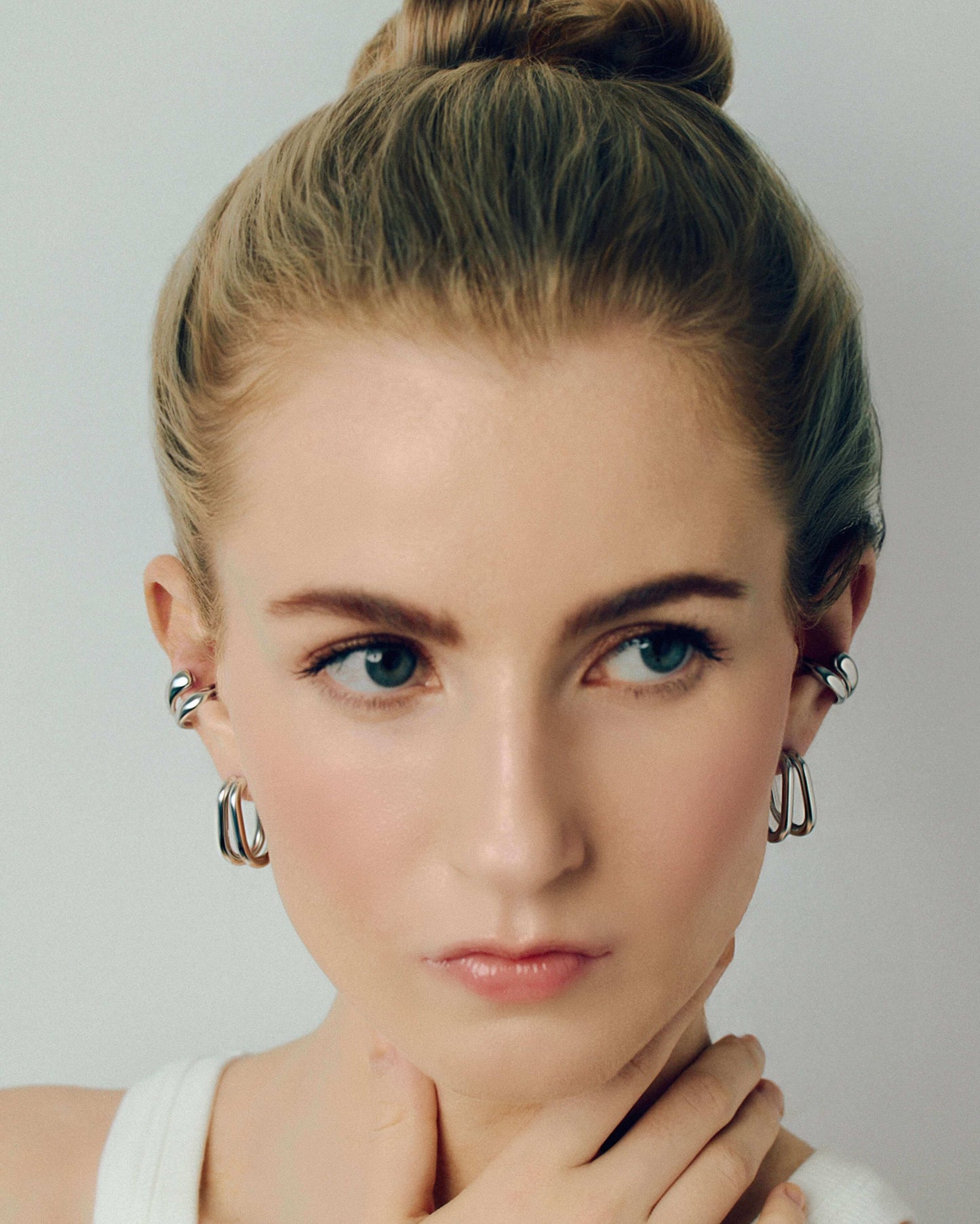 Gold double hoop earrings featuring two thick, sculptural curved bands with a polished high-shine finish. Modern layered design with secure post backs, creating a bold yet minimalist statement. Perfect for everyday wear or adding a stylish, contemporary touch to any outfit.