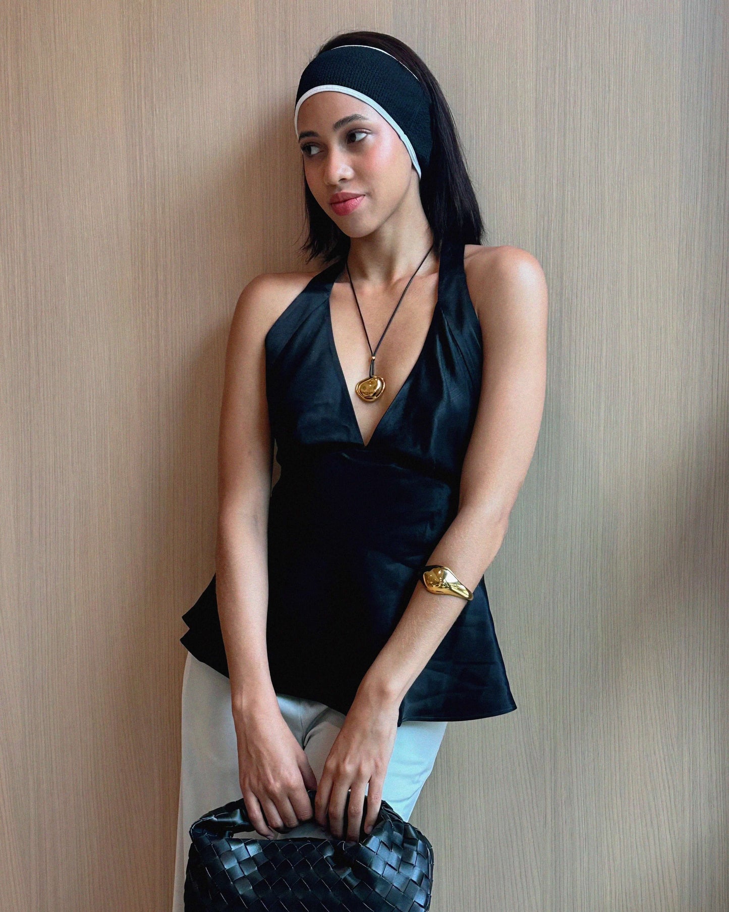 Oversized bean pendant on a polished black tie chain with 18k gold or silver finish, adjustable length, sleek modern minimalist design.