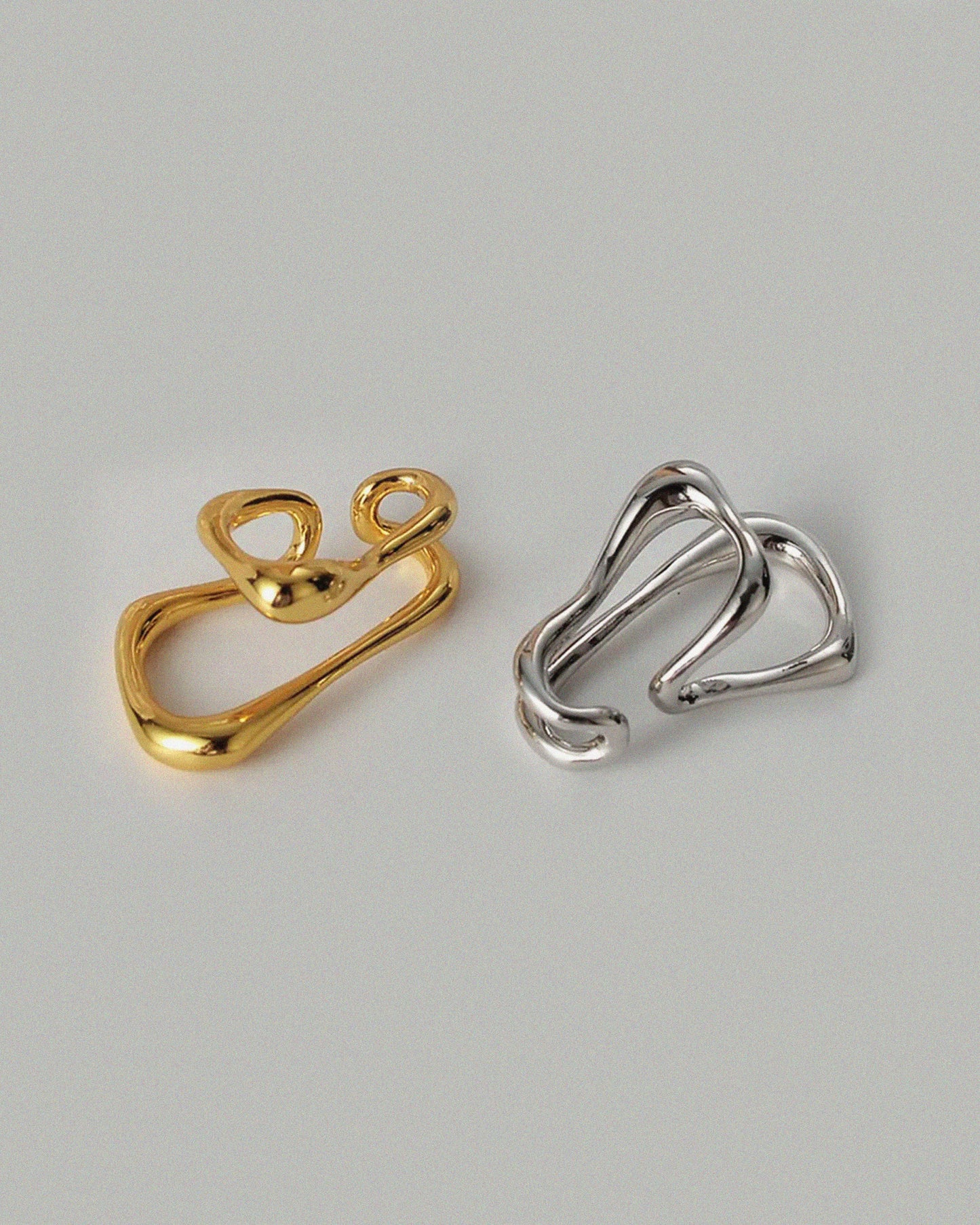 Oversized clip-on earrings in gold and silver versions. These sculptural, teardrop-shaped earrings feature a smooth, fluid form that wraps elegantly around the earlobe. Designed for non-pierced ears, they offer a bold, modern statement with a comfortable fit. Perfect for elevating everyday looks or adding a refined touch to evening outfits.