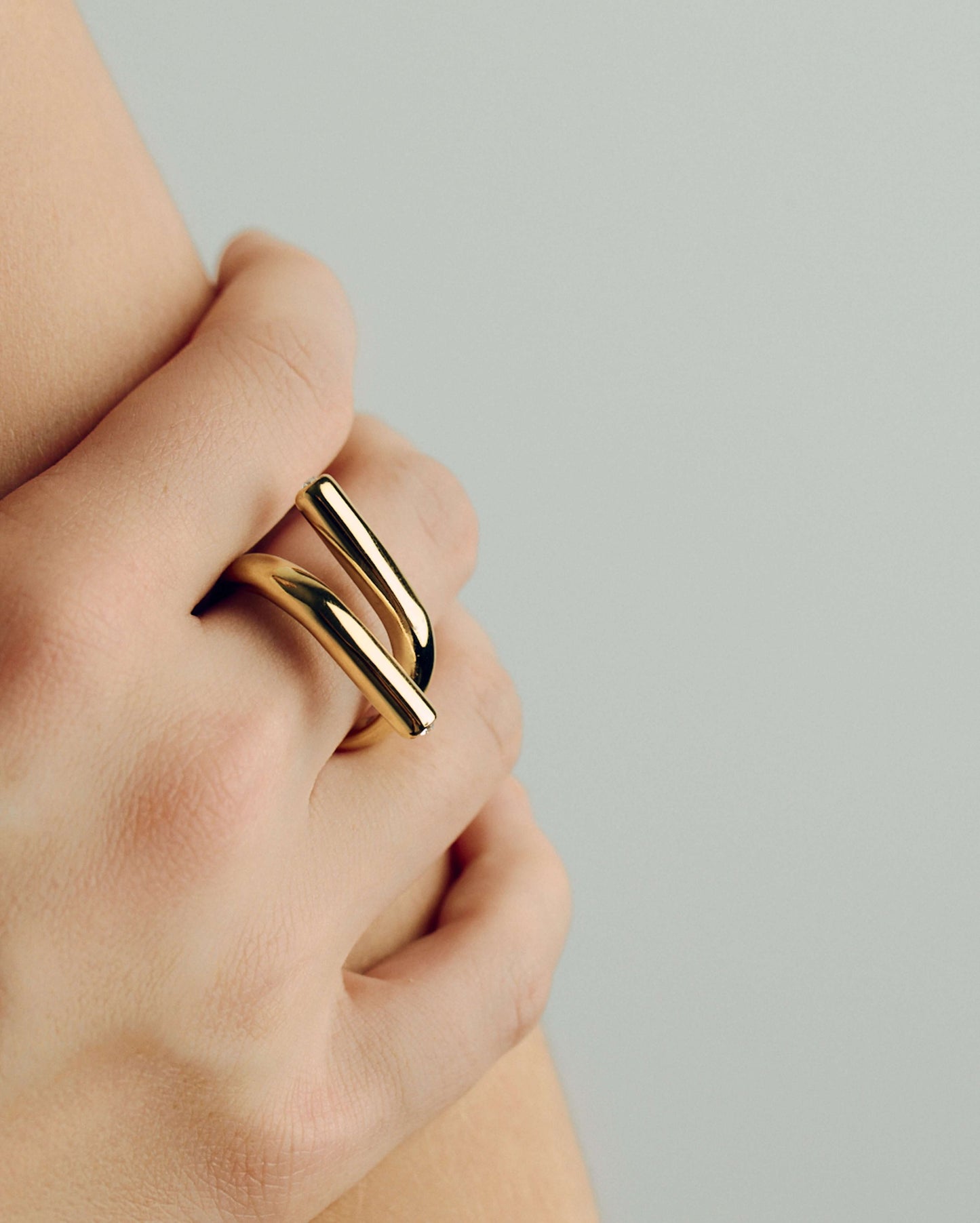 Gold open twist ring with sculptural wrap design, minimal statement band for stacking or solo wear
