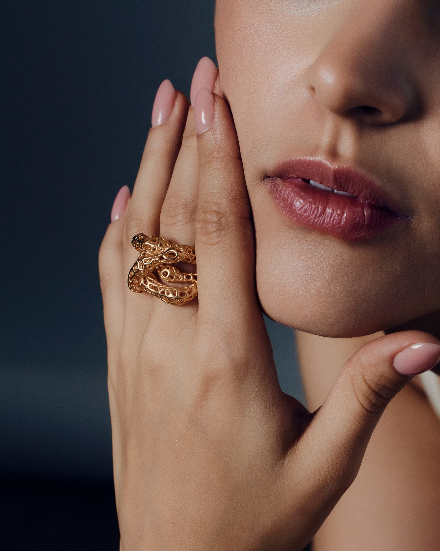 Gold open-work knot ring with a sculptural, intertwined design and wide textured band. This chunky statement ring features organic cutout details that create a bold yet airy look. Crafted in polished gold-tone metal, it blends modern artistry with everyday wearability — ideal as a solo statement piece or stacked with minimalist bands.