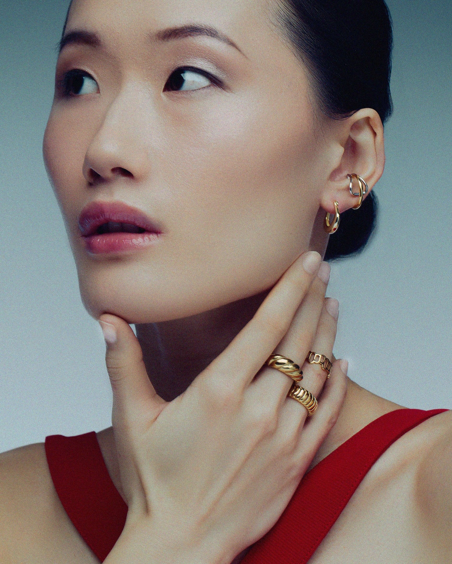 Two-tone ear cuff featuring a sleek wrap-around design in gold and silver, offering a modern, non-pierced accessory for versatile styling.
