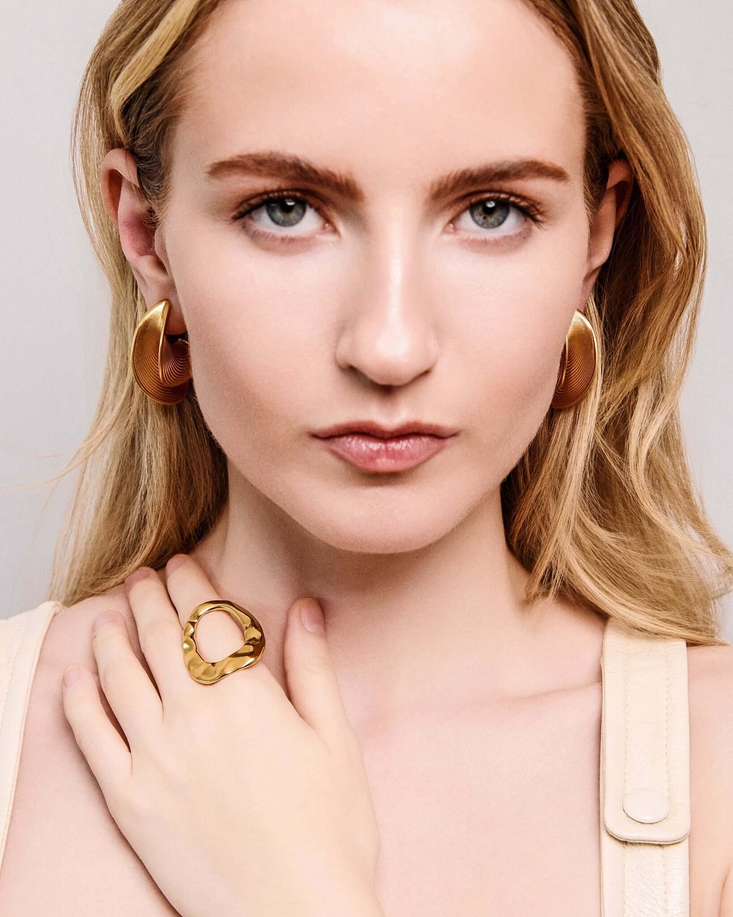 Sculptural ribbed hoop earrings in gold finish, bold textured statement hoops for women, modern curved hoop earrings, contemporary minimalist jewelry, chunky ribbed gold earrings for everyday wear or elevated evening styling