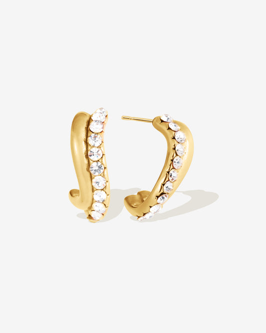 Gold wavy CZ hoop earrings with sparkling pavé crystal stones, curved huggie hoop earrings for women, modern gold statement hoops, lightweight everyday earrings, trendy fashion jewelry, sculptural gold hoops, elegant gift for her.