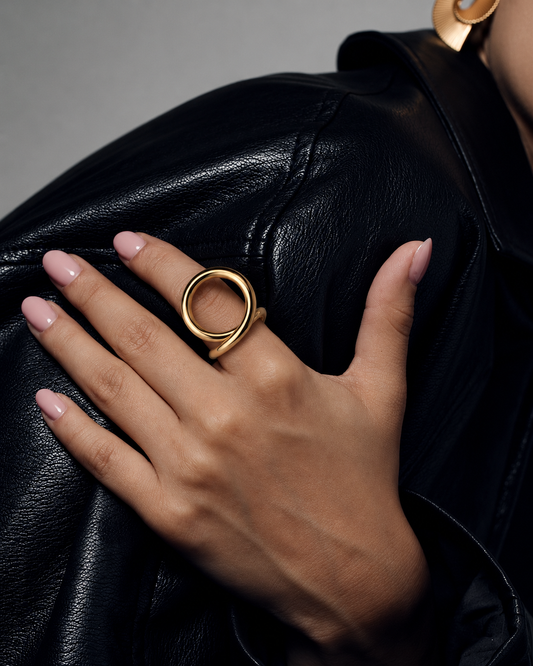 Sculptural loop ring in polished gold and silver with an oversized fluid open-loop silhouette and modern statement design by RRule