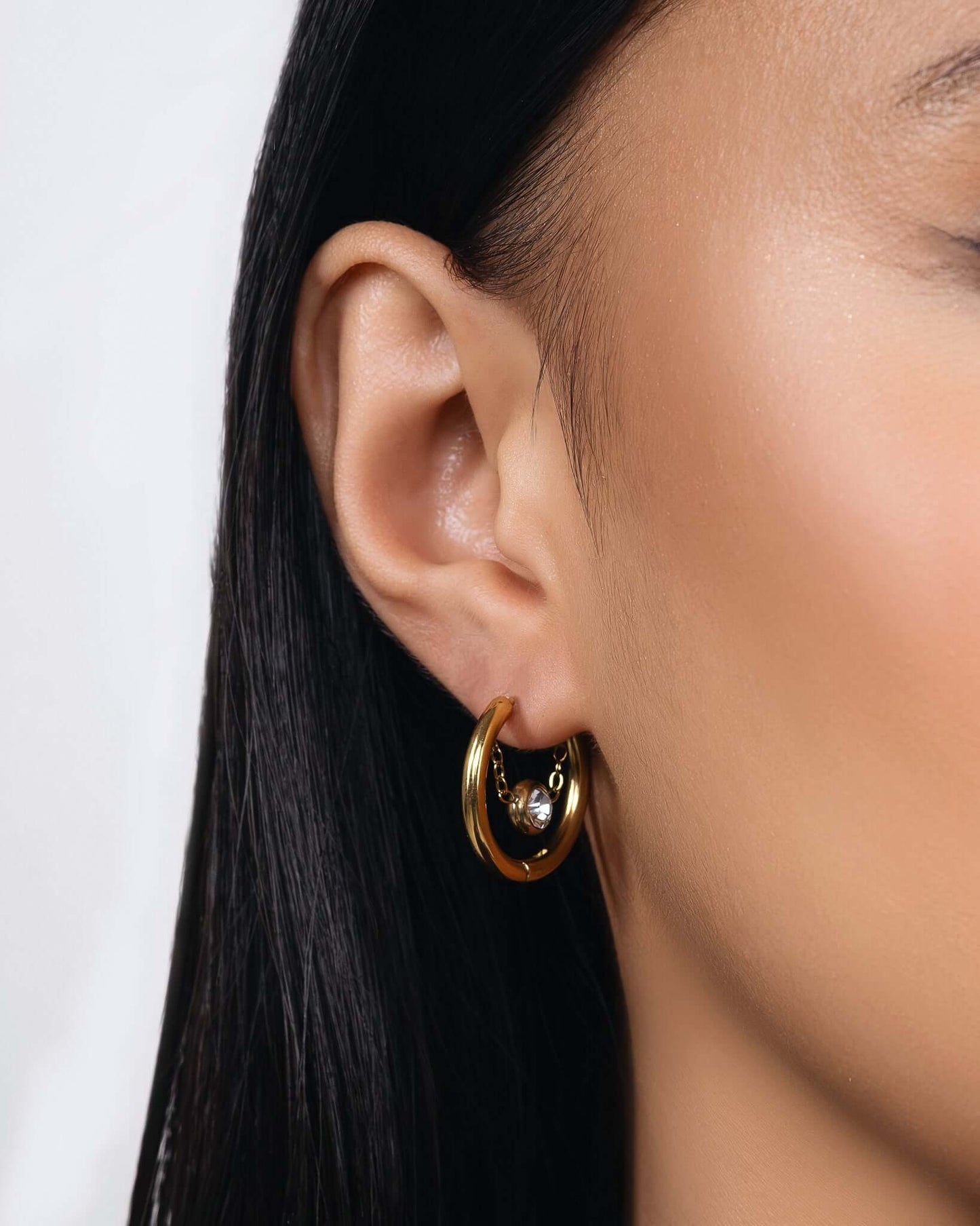 Gold crystal hoop chain earrings with dangling clear gemstone detail, modern chunky hoop earrings for women, minimalist statement jewelry, trendy gold hoops with chain accent, elegant everyday or party earrings gift for her