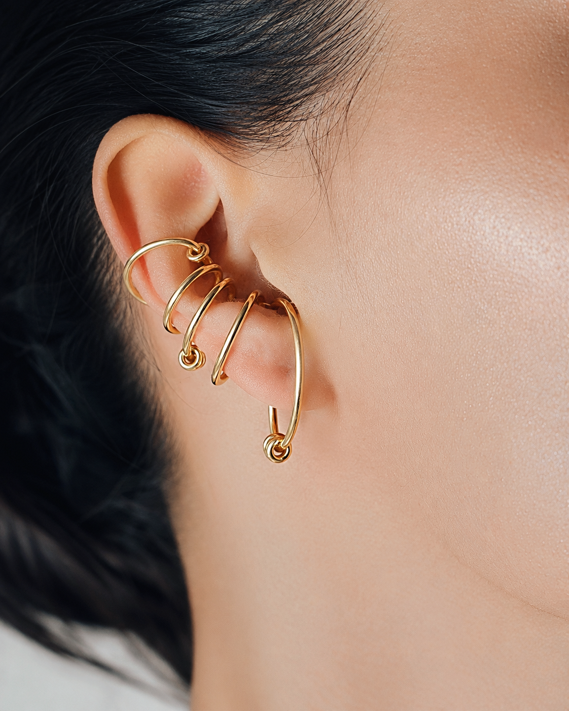Statement ear cuff in gold featuring a sculptural multi loop design