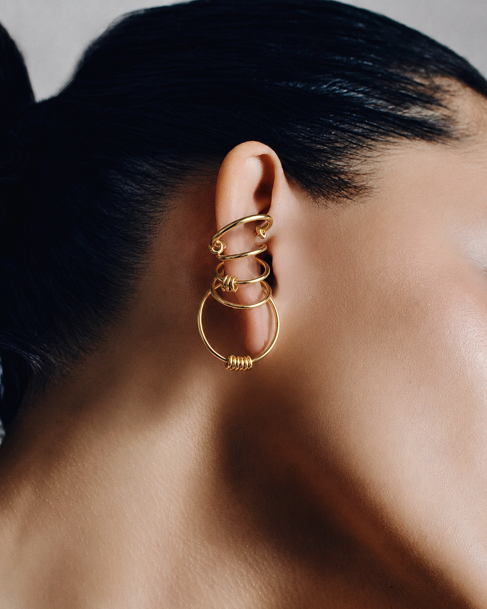 Statement ear cuff in gold featuring a sculptural multi loop design