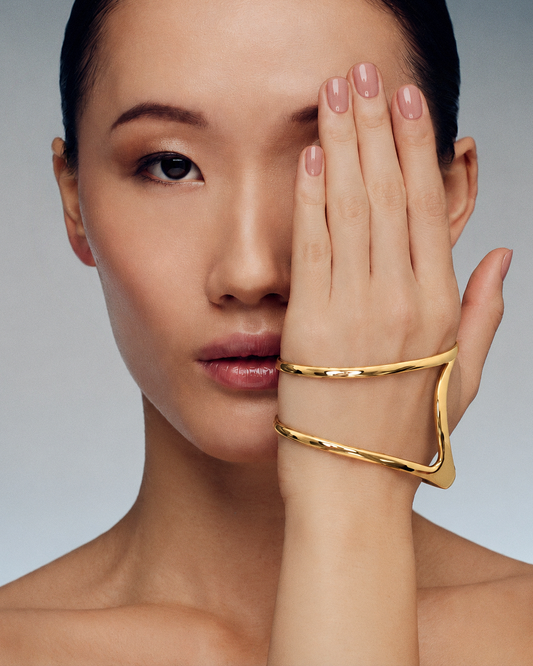 Palm cuff bracelet in gold and silver featuring a polished fluid silhouette, sculptural open hand bracelet design and modern statement jewelry by RRule