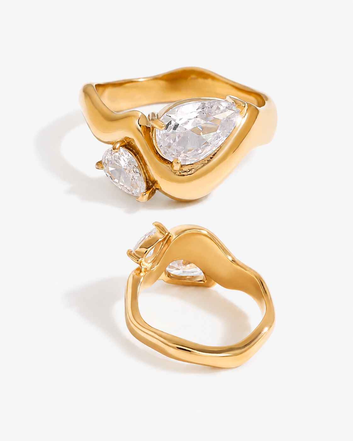 Pear cut crystal ring in polished gold with two sparkling pear-shaped stones, sculptural asymmetric band and modern statement jewelry design by RRule