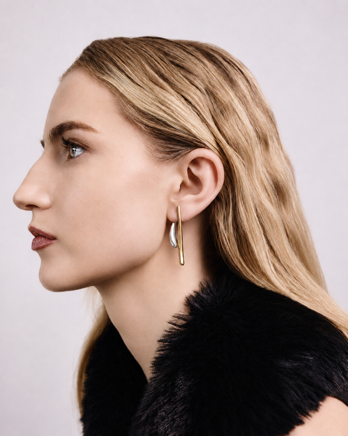 Two tone ear jacket earrings in polished gold and silver with sculptural curved bars, teardrop drop details and a modern mixed metal statement design by RRule