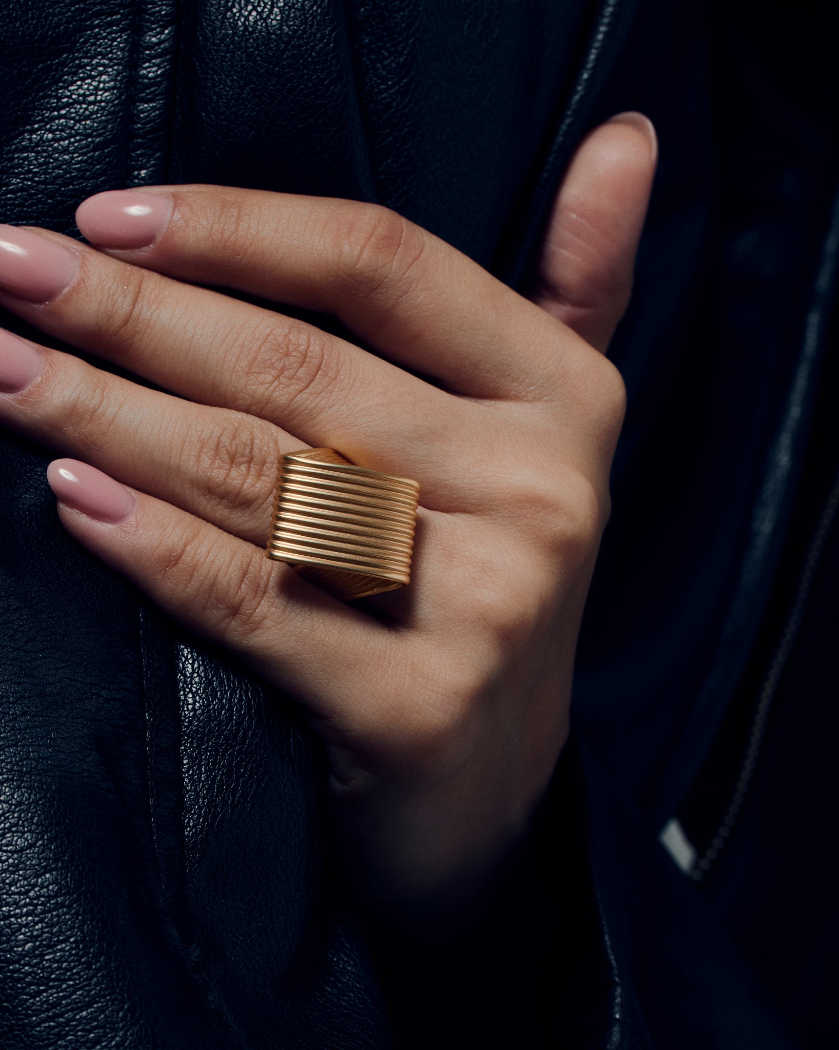 Pleated square gold ring featuring fine ridged detailing that flows seamlessly across the face and band. This sculptural textured ring combines a bold square shape with a soft pleated design, balancing modern geometry and fluid form. Crafted in polished gold-tone metal, it’s a statement piece for everyday or occasion wear.