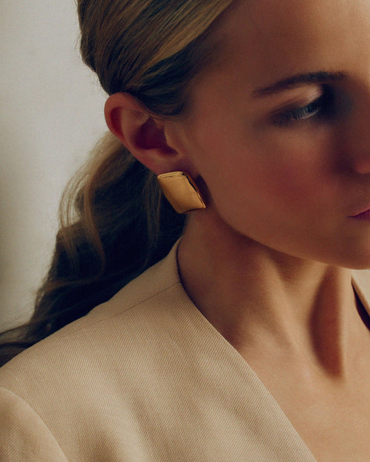 Bold gold rectangle stud earrings with a chunky, sculptural design and high-shine finish. Modern geometric statement studs perfect for everyday or occasion wear.