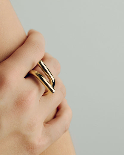 Gold open twist ring with sculptural wrap design, minimal statement band for stacking or solo wear