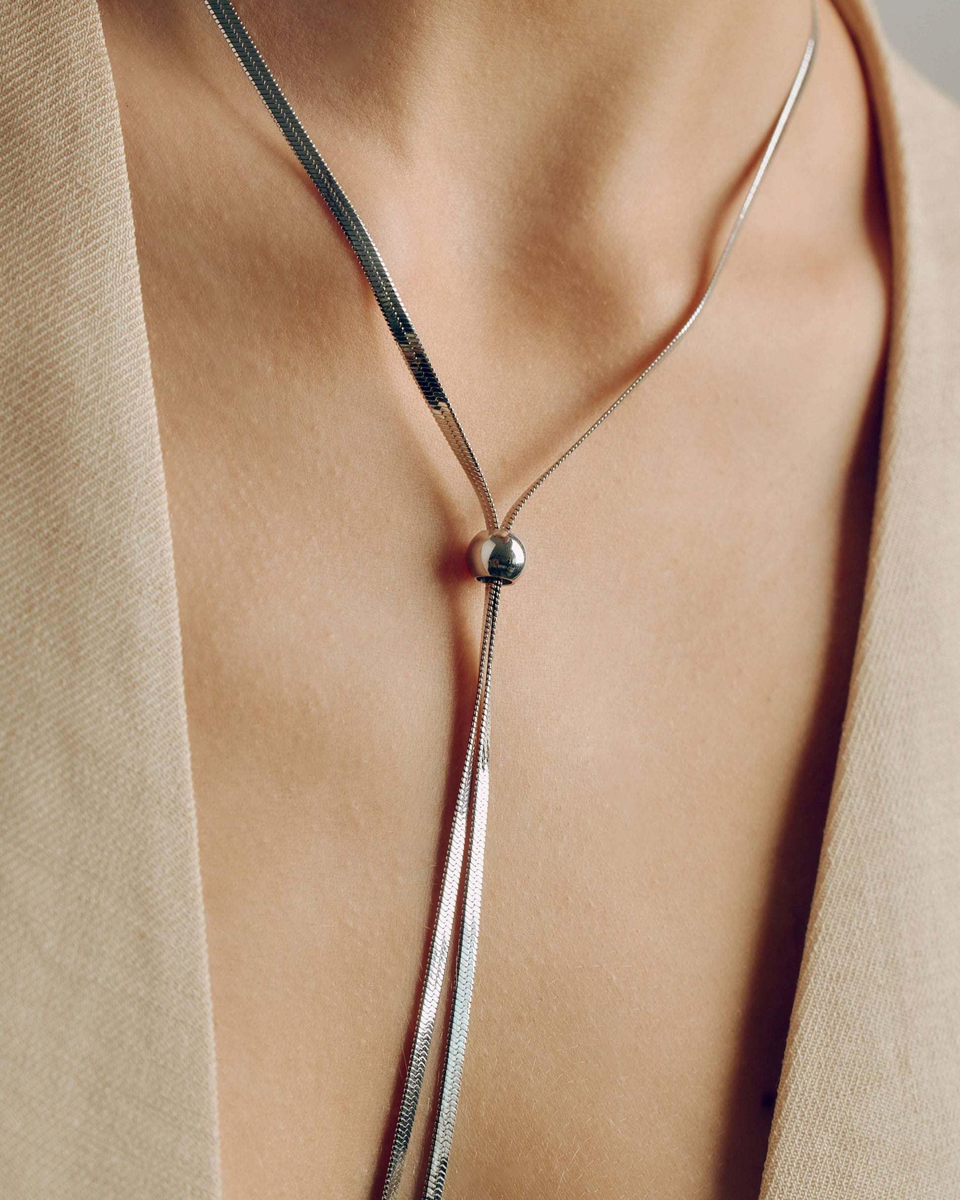 Adjustable gold or silver necklace with sleek snake chain and drop strands, wearable long or as a choker.