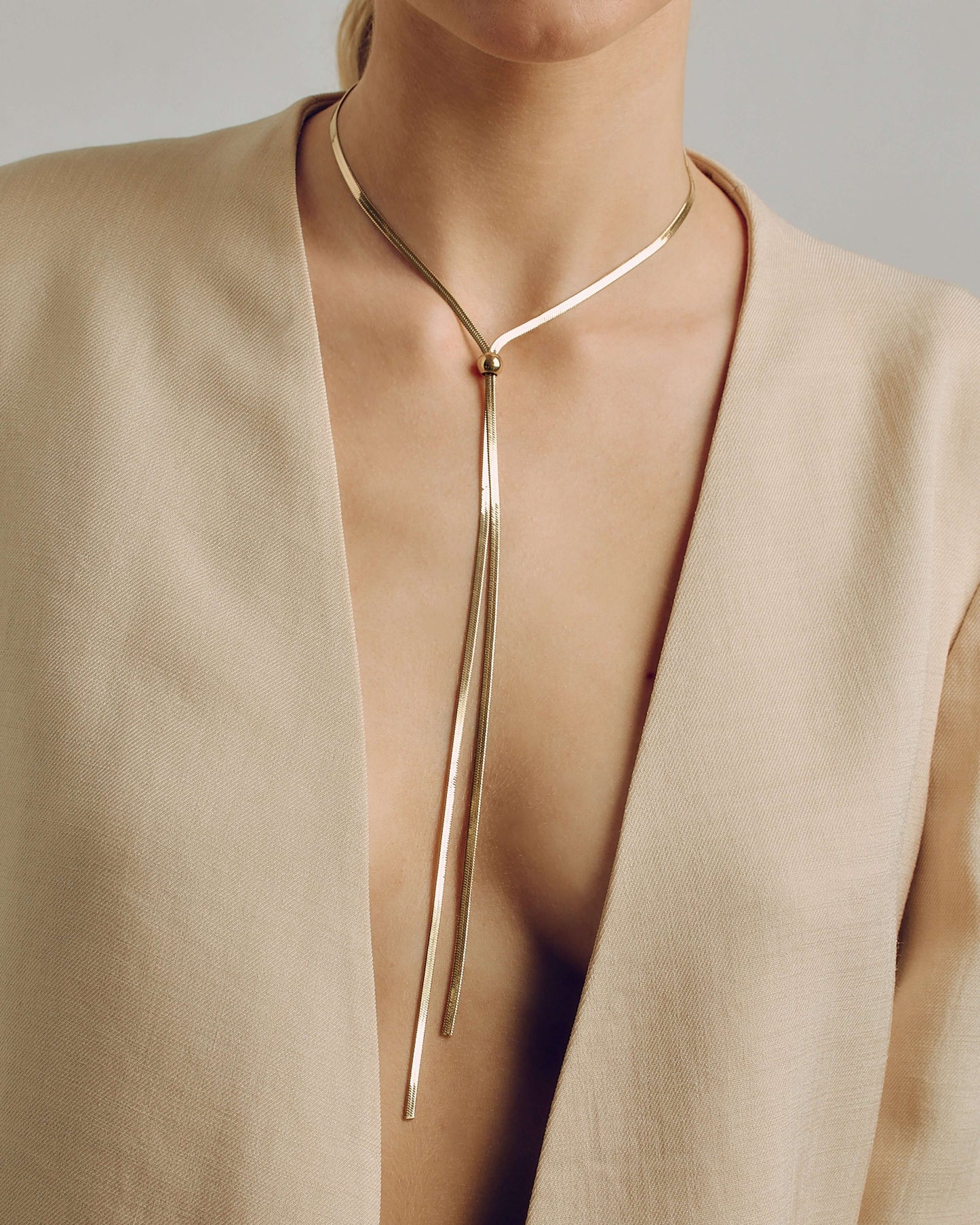 Adjustable gold or silver necklace with sleek snake chain and drop strands, wearable long or as a choker.