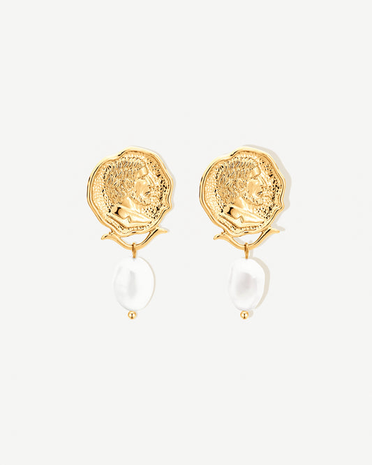 Gold earrings with medallion engraving and pearl drop on a white background