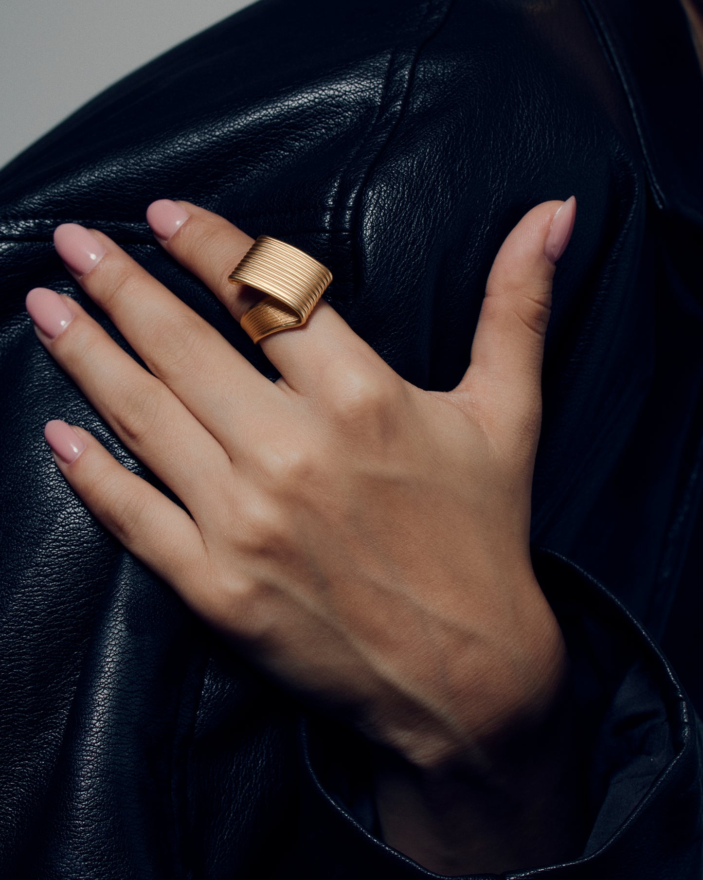 Pleated square gold ring featuring fine ridged detailing that flows seamlessly across the face and band. This sculptural textured ring combines a bold square shape with a soft pleated design, balancing modern geometry and fluid form. Crafted in polished gold-tone metal, it’s a statement piece for everyday or occasion wear.