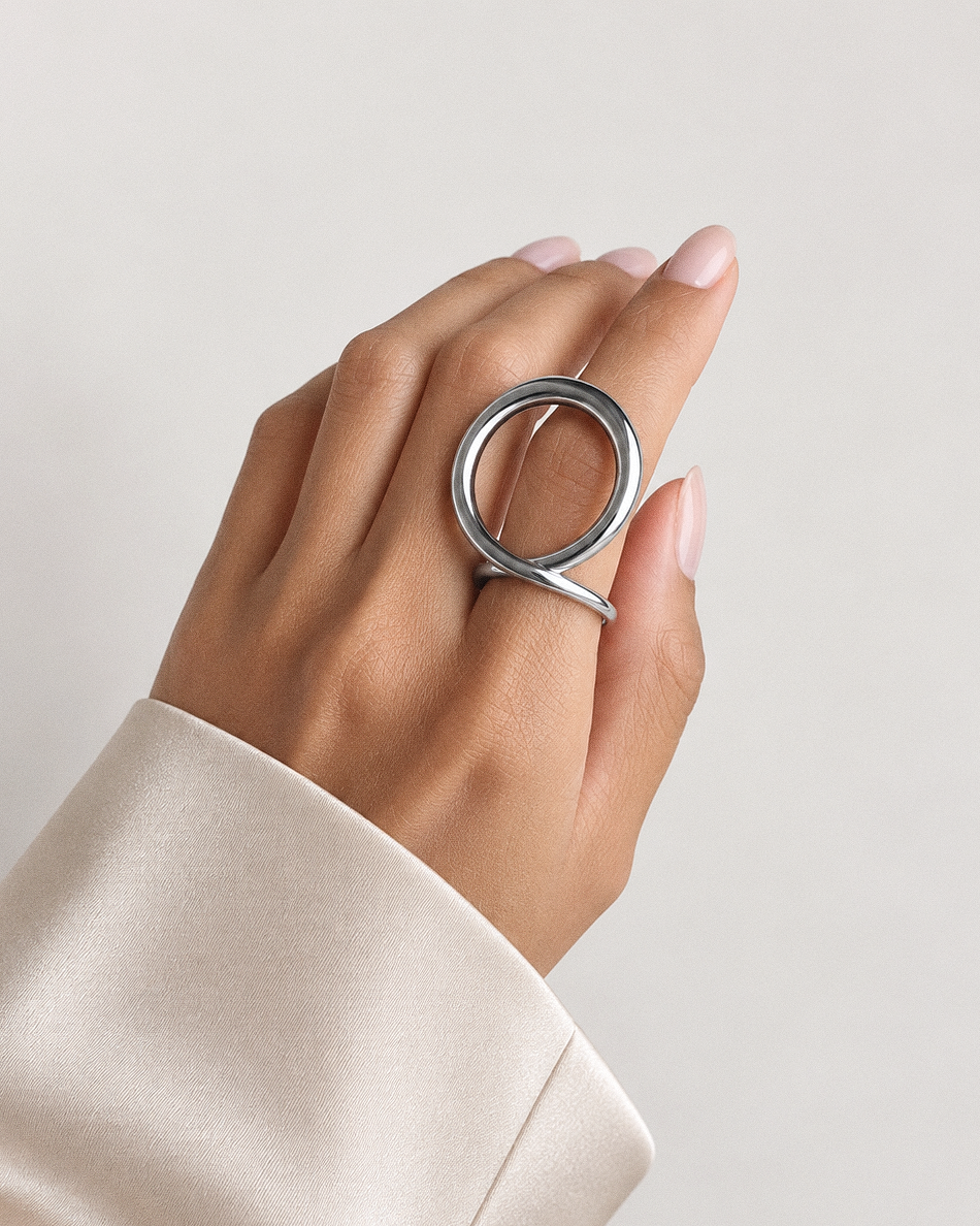 Sculptural loop ring in polished gold and silver with an oversized fluid open-loop silhouette and modern statement design by RRule