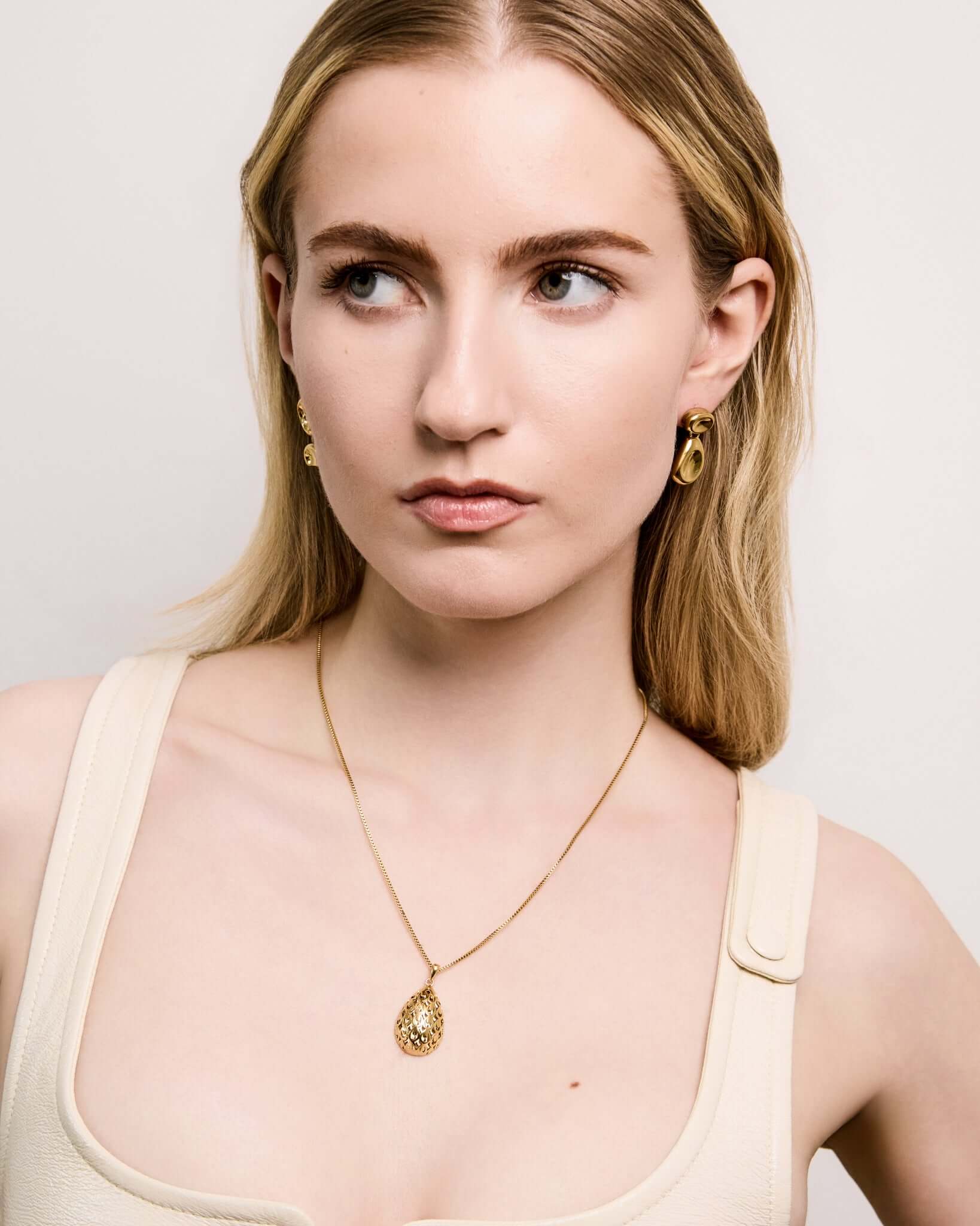 Double Bean Drop Earrings in gold or silver finish featuring a sculptural organic bean design, polished statement drop earrings, modern minimalist jewelry, chunky contemporary earrings for everyday wear and special occasions.