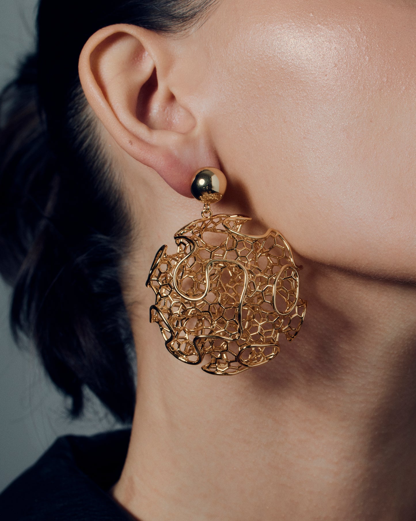 Gold filigree statement earrings featuring a sculptural open-work orb design with intricate detailing and polished gold finish. These large hollow drop earrings blend traditional filigree artistry with a modern, sculptural form, creating a bold yet refined statement. Perfect for those who love elegant, lightweight, and wearable art jewelry.