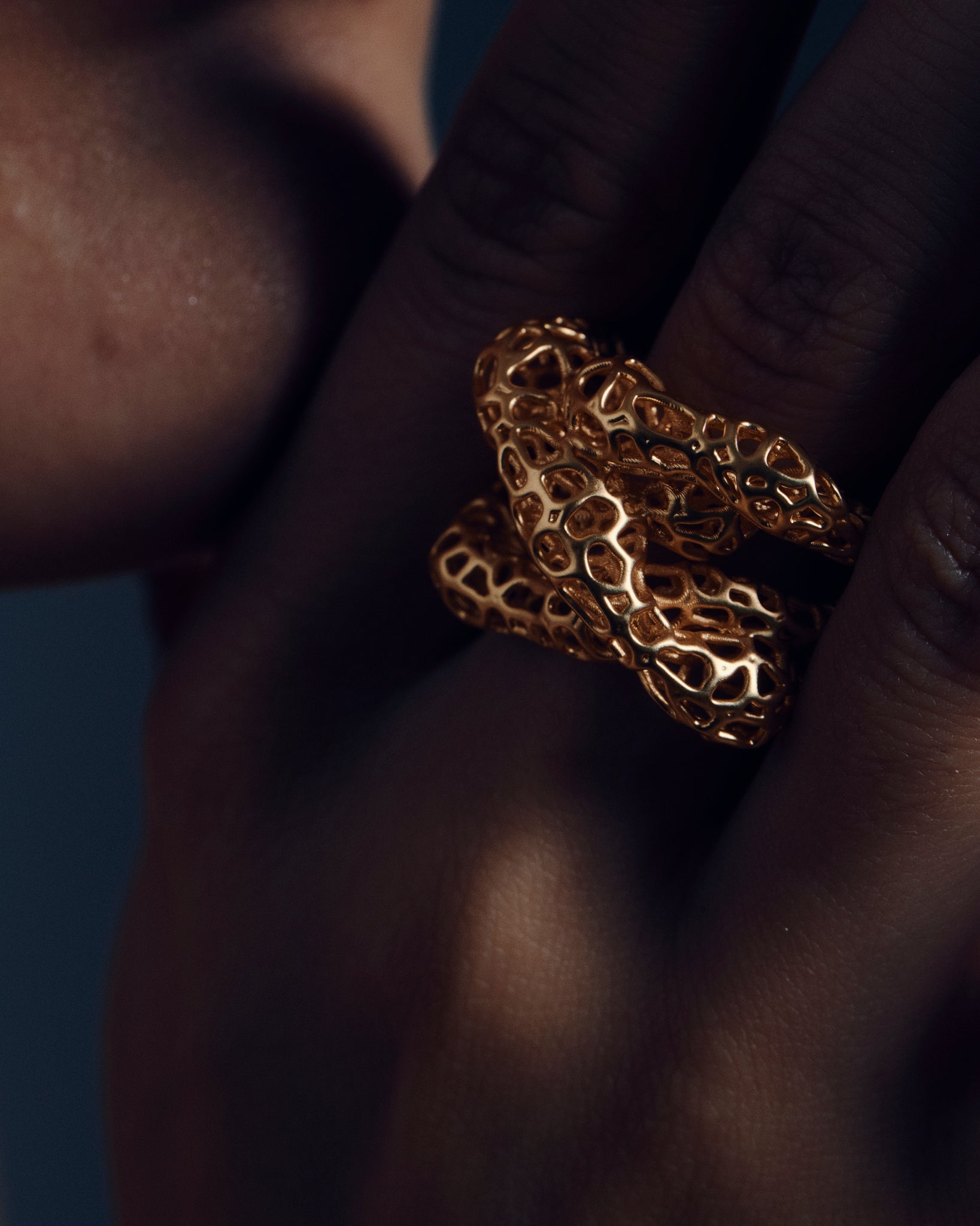 Gold open-work knot ring with a sculptural, intertwined design and wide textured band. This chunky statement ring features organic cutout details that create a bold yet airy look. Crafted in polished gold-tone metal, it blends modern artistry with everyday wearability — ideal as a solo statement piece or stacked with minimalist bands.