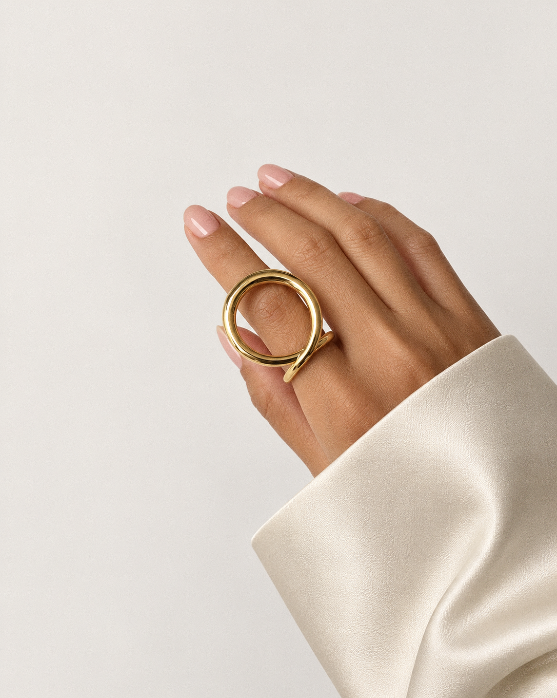 Sculptural loop ring in polished gold and silver with an oversized fluid open-loop silhouette and modern statement design by RRule