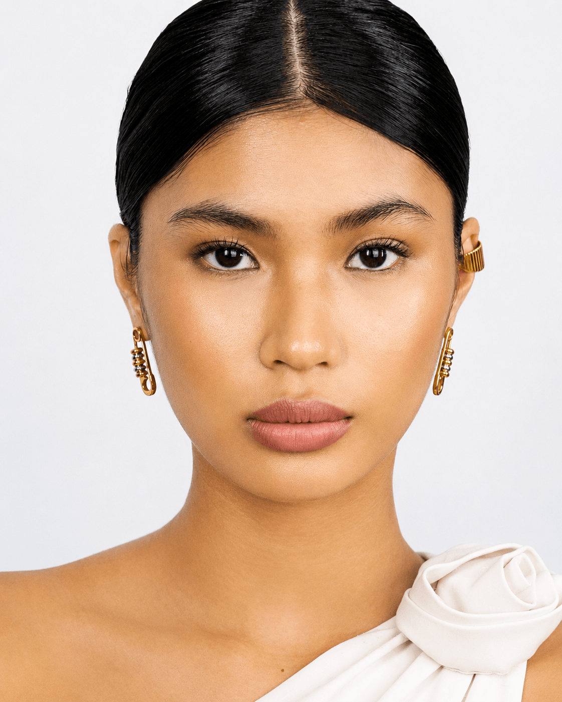 Gold safety pin earrings with silver bead details worn on ear, chunky statement earrings for women, modern two tone jewelry, edgy minimalist gold hoop earrings, trendy everyday fashion accessory, unique punk inspired earrings, stainless steel safety pin d