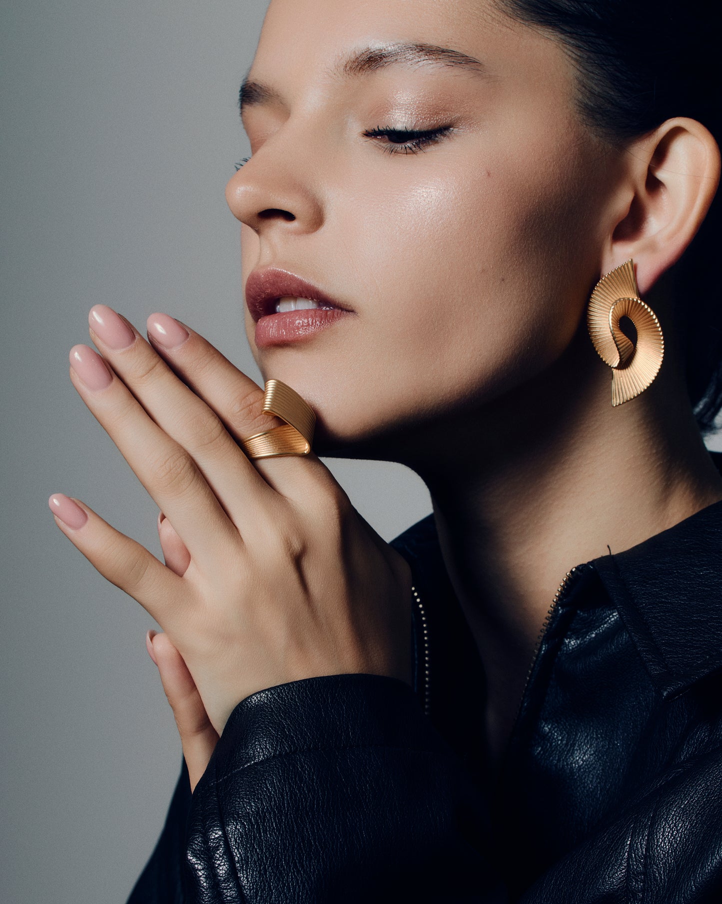 Pleated sculptural gold earrings featuring a twisted, folded design with fine ridged texture. These bold statement earrings have an open curved form that adds dimension and movement. Crafted in polished gold-tone metal, they bring a modern, architectural edge to any outfit — lightweight yet striking for everyday or occasion wear.