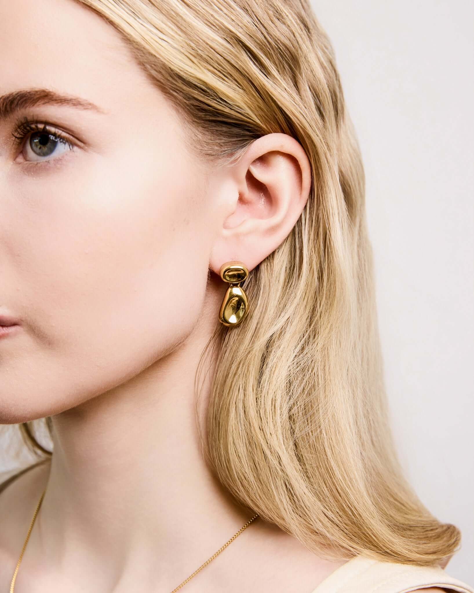 Double Bean Drop Earrings in gold or silver finish featuring a sculptural organic bean design, polished statement drop earrings, modern minimalist jewelry, chunky contemporary earrings for everyday wear and special occasions.