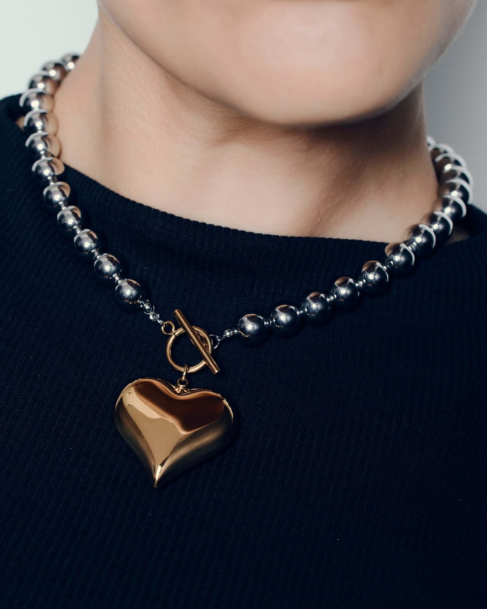 Two tone heart pendant necklace with polished gold heart charm on silver ball chain and front toggle clasp chunky statement jewelry for women