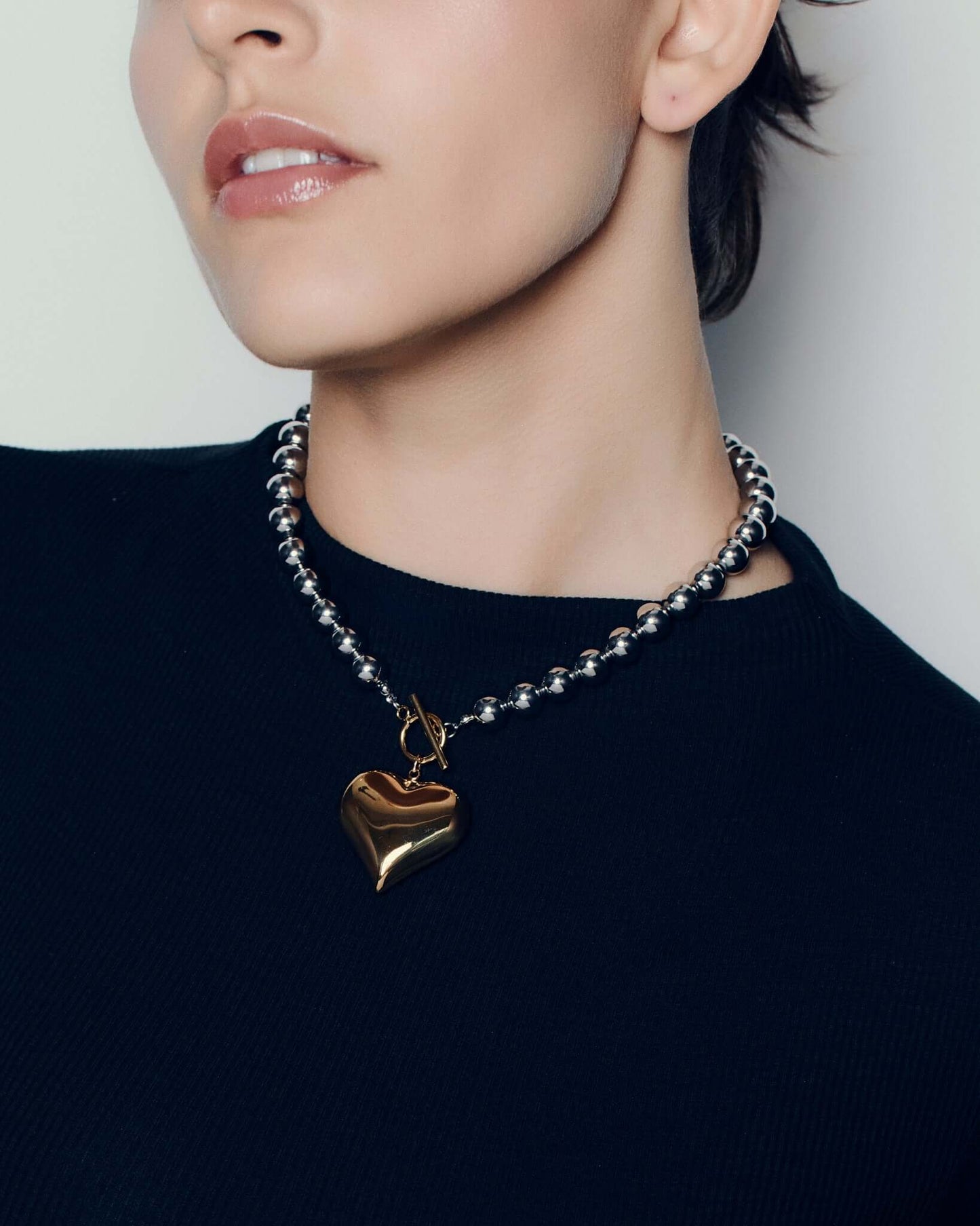 Two tone heart pendant necklace with polished gold heart charm on silver ball chain and front toggle clasp chunky statement jewelry for women