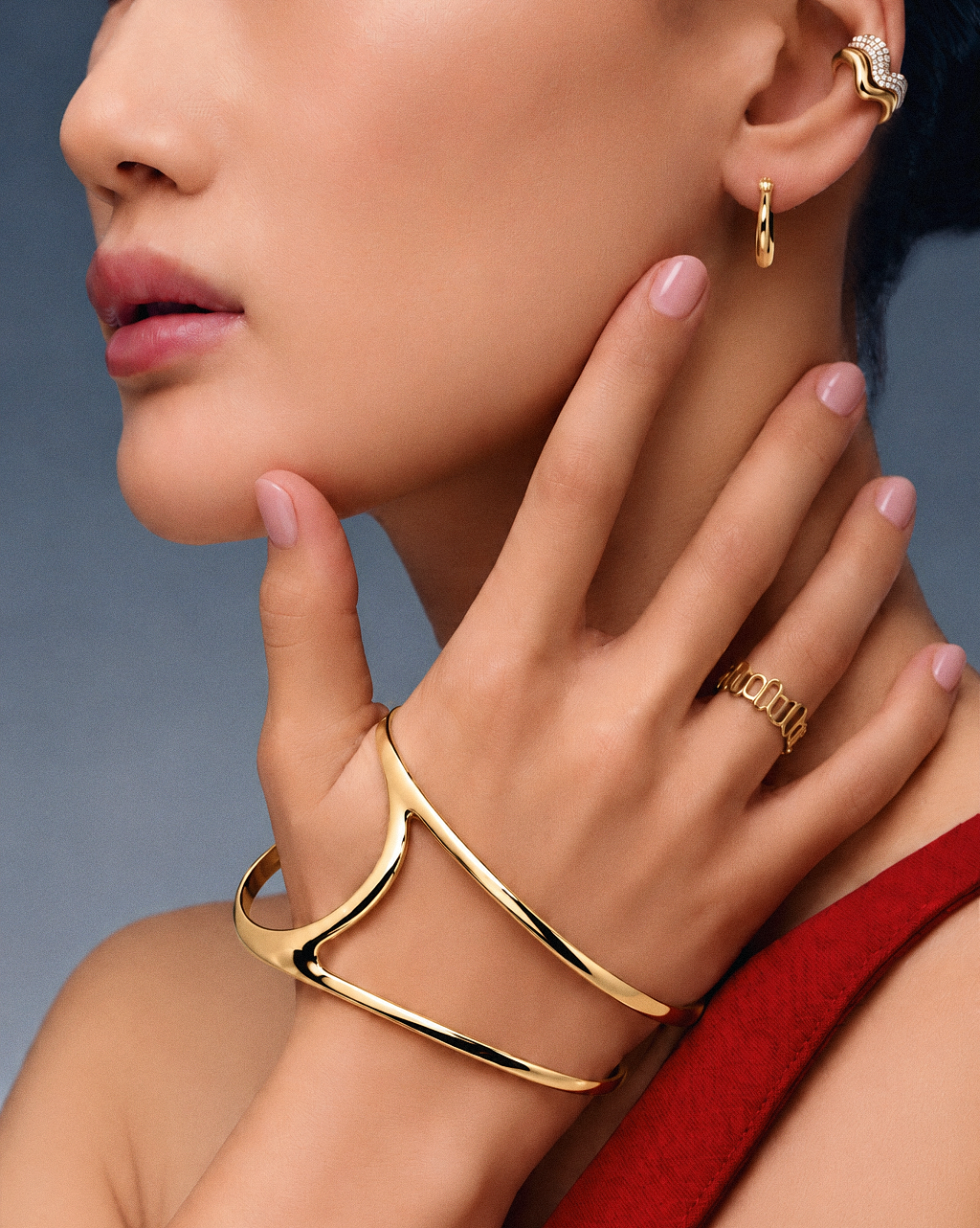 Palm cuff bracelet in gold and silver featuring a polished fluid silhouette, sculptural open hand bracelet design and modern statement jewelry by RRule