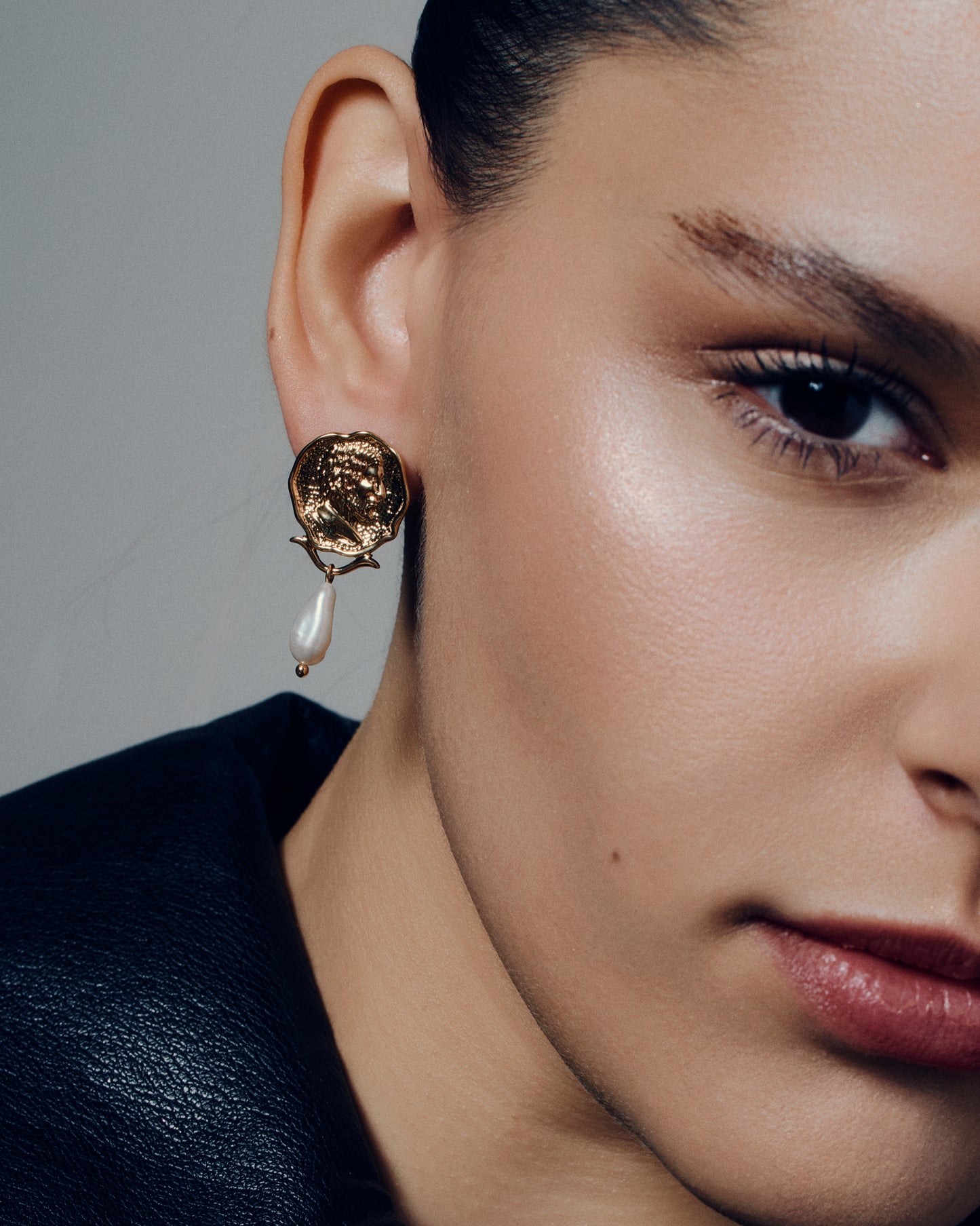 Gold coin pearl drop earrings featuring embossed medallion faces paired with natural baroque-style pearls. These sculptural statement earrings combine vintage inspiration with modern craftsmanship, offering a timeless yet bold look. Perfect for elevating everyday or occasion outfits with a touch of classic gold elegance.
