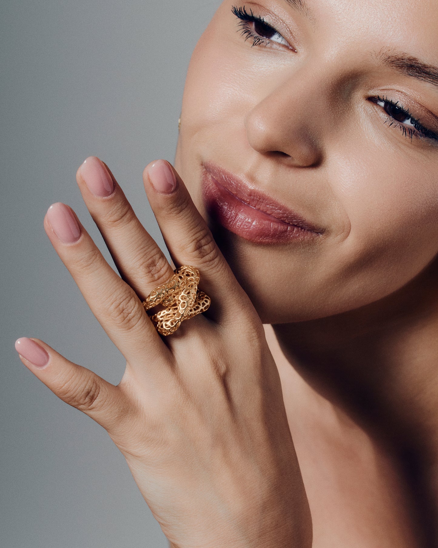 Gold open-work knot ring with a sculptural, intertwined design and wide textured band. This chunky statement ring features organic cutout details that create a bold yet airy look. Crafted in polished gold-tone metal, it blends modern artistry with everyday wearability — ideal as a solo statement piece or stacked with minimalist bands.