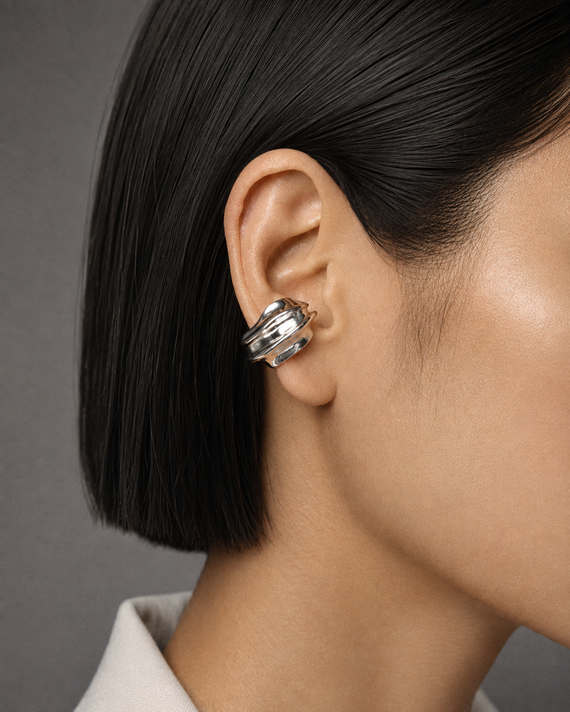 Silver ear cuff abstract statement jewelry with fluid curved dome shape and polished silver finish