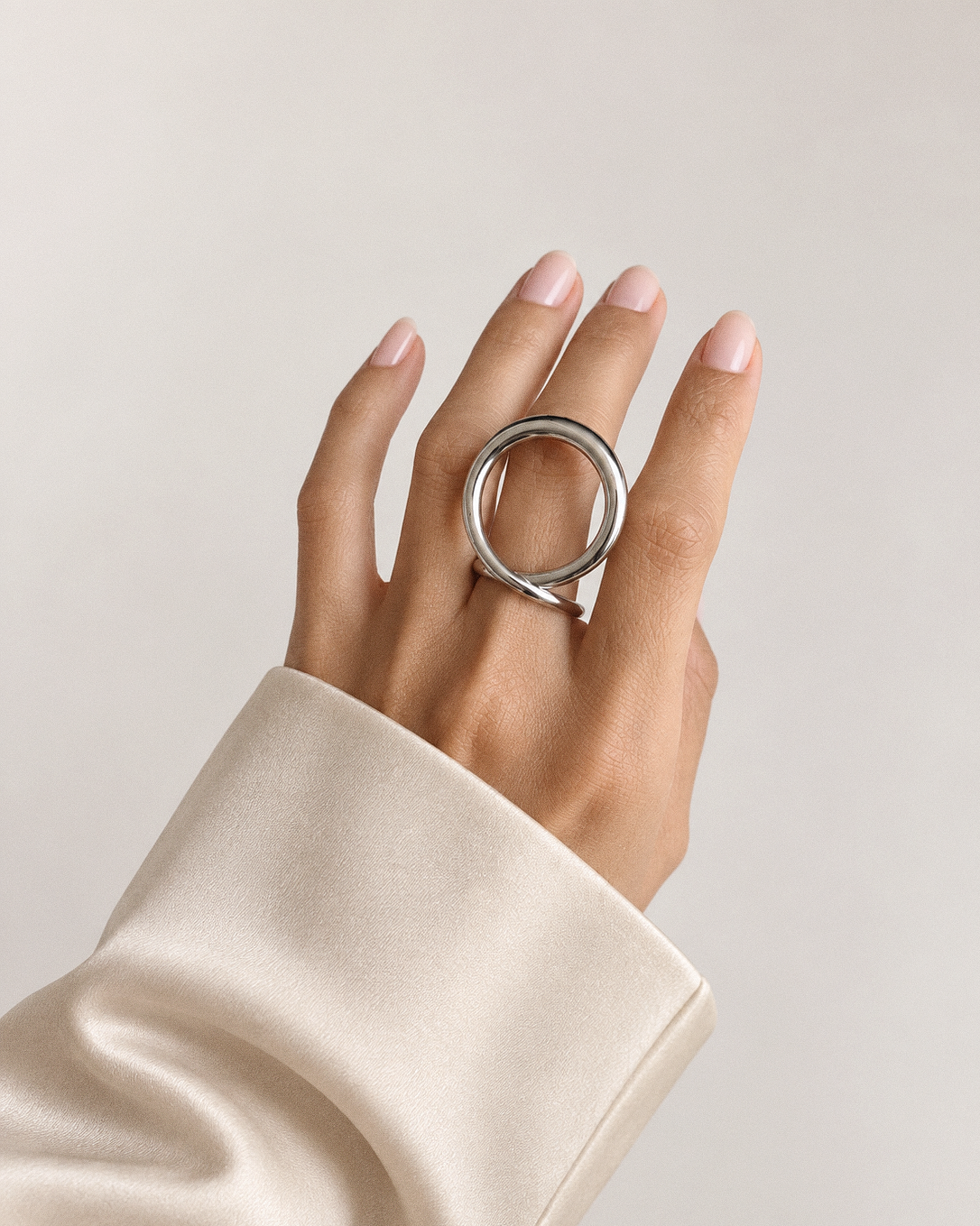Sculptural loop ring in polished gold and silver with an oversized fluid open-loop silhouette and modern statement design by RRule