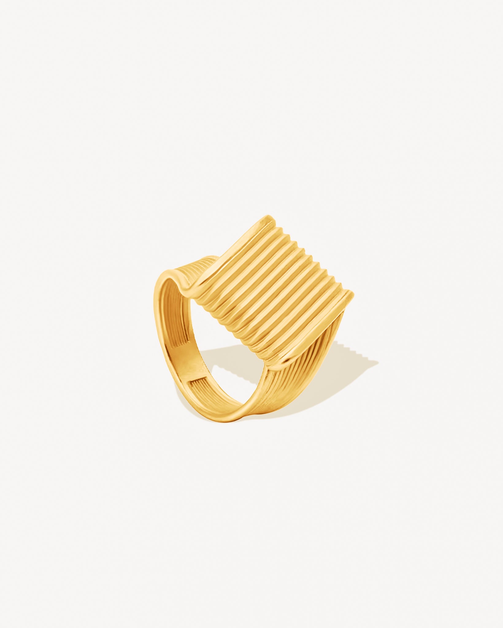 gold chunky ring with ribbed design on a white background