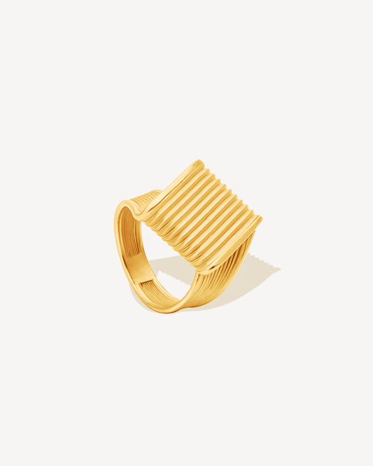 gold chunky ring with ribbed design on a white background