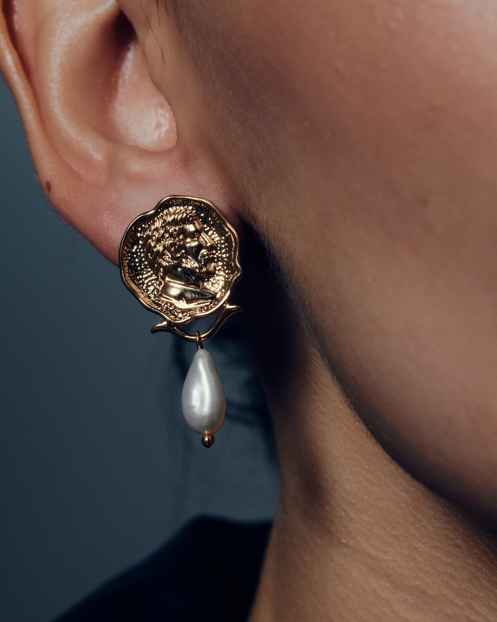 Gold coin pearl drop earrings featuring embossed medallion faces paired with natural baroque-style pearls. These sculptural statement earrings combine vintage inspiration with modern craftsmanship, offering a timeless yet bold look. Perfect for elevating everyday or occasion outfits with a touch of classic gold elegance.