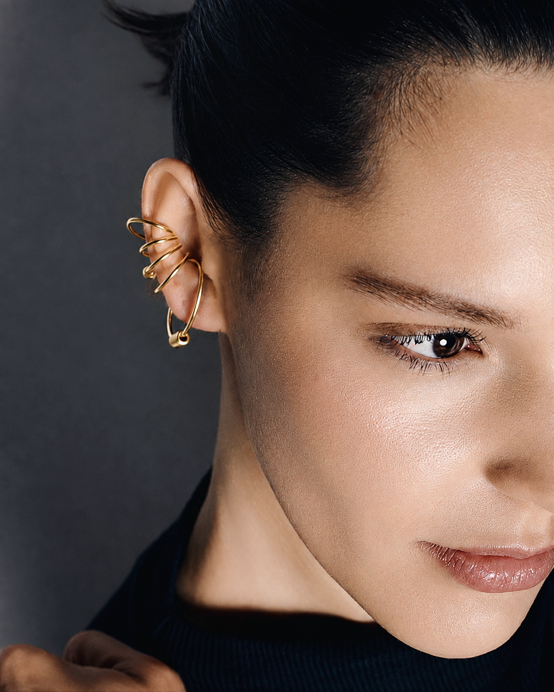 Statement ear cuff in gold featuring a sculptural multi loop design