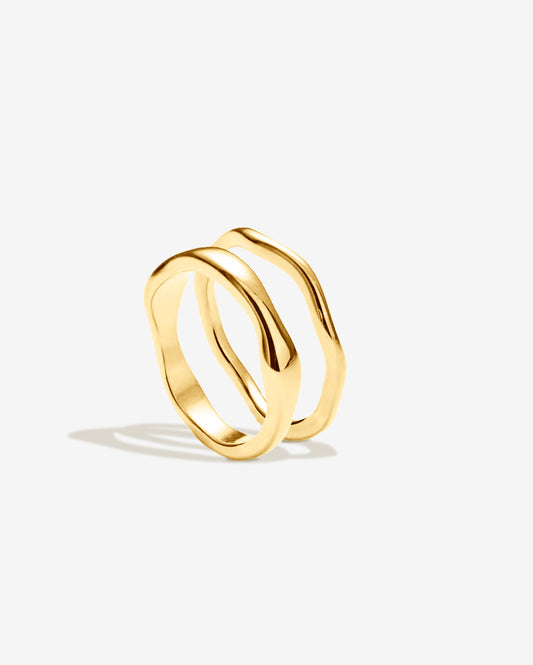 Gold wavy double ring featuring two curved, complementary bands — one thick and one thin — with a smooth, polished finish. Modern minimalist gold ring designed for everyday wear or stacking.