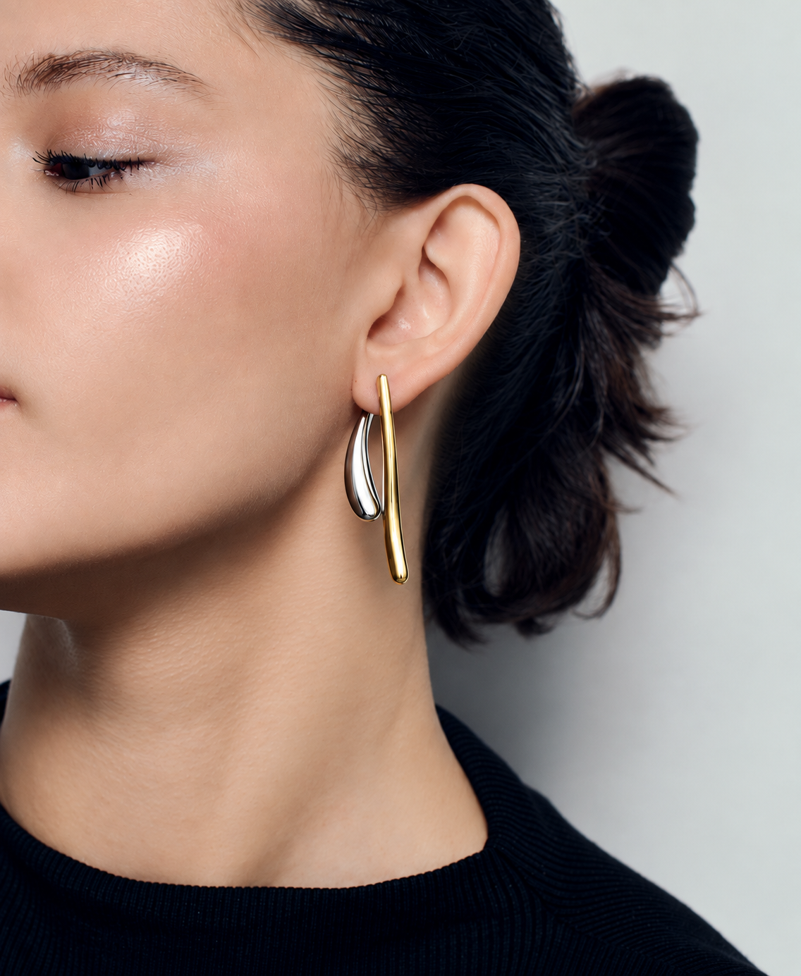 Two tone ear jacket earrings in polished gold and silver with sculptural curved bars, teardrop drop details and a modern mixed metal statement design by RRule