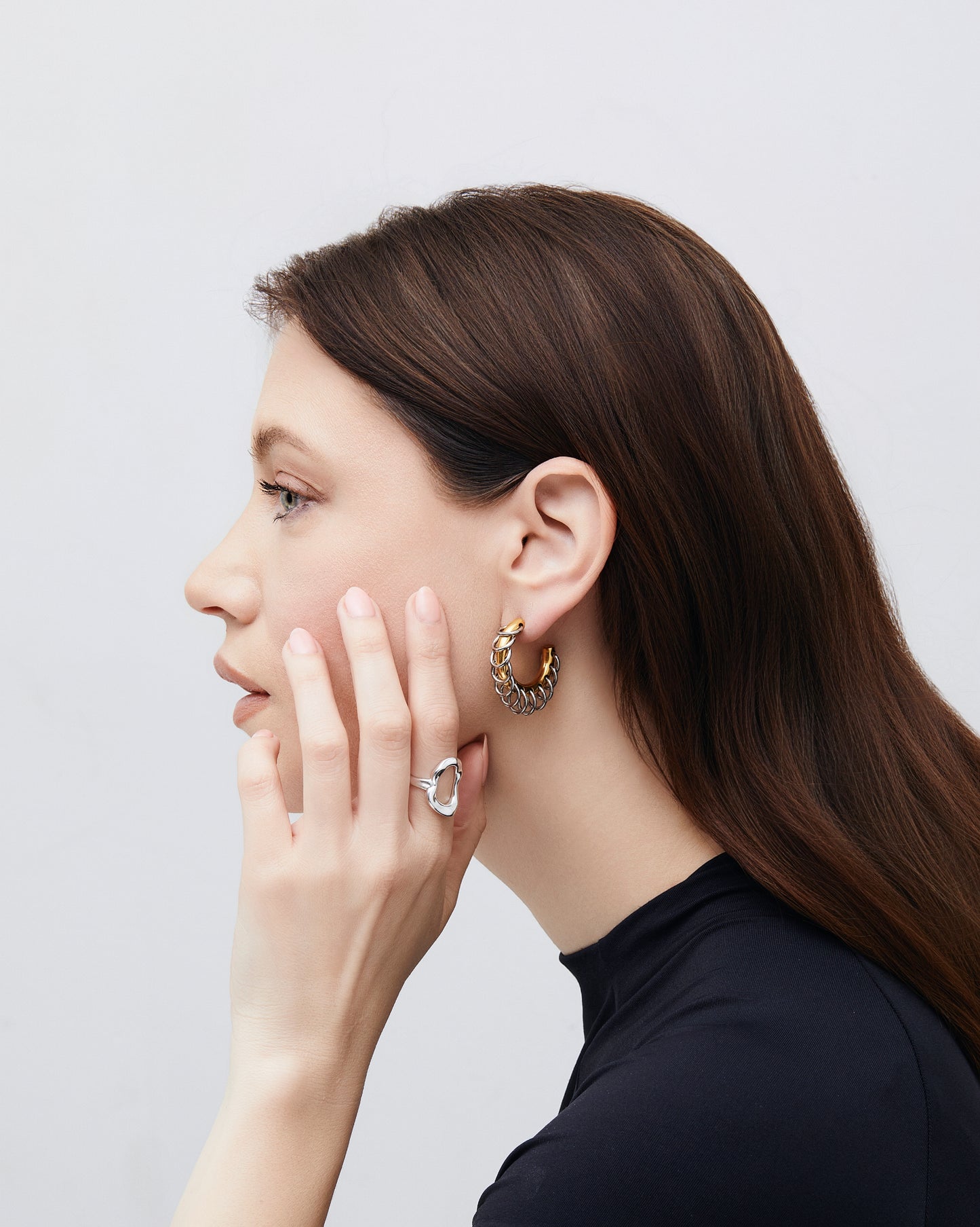 Two-tone chunky hoop earrings featuring interlocking gold and silver loops in a sculptural, modern design. The mixed-metal finish creates a bold yet refined statement look, perfect for everyday wear or special occasions. These contemporary hoops add dimension and shine, effortlessly complementing minimalist or statement jewelry styles. Ideal for those who love elevated, modern accessories.