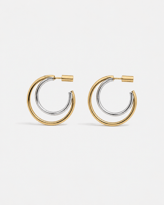 Modern two tone double hoop earrings featuring a polished gold outer hoop and silver inner hoop with secure tube lock closure, minimalist mixed metal statement earrings for everyday wear and modern jewelry styling.