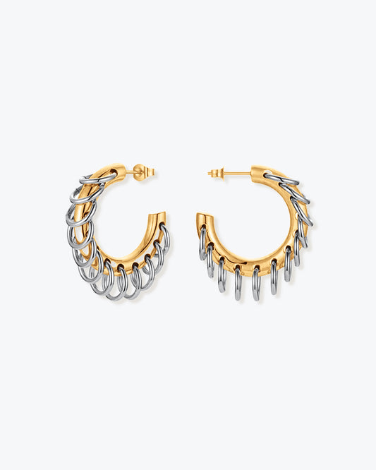 Two-tone chunky hoop earrings featuring interlocking gold and silver loops in a sculptural, modern design. The mixed-metal finish creates a bold yet refined statement look, perfect for everyday wear or special occasions. These contemporary hoops add dimension and shine, effortlessly complementing minimalist or statement jewelry styles. Ideal for those who love elevated, modern accessories.