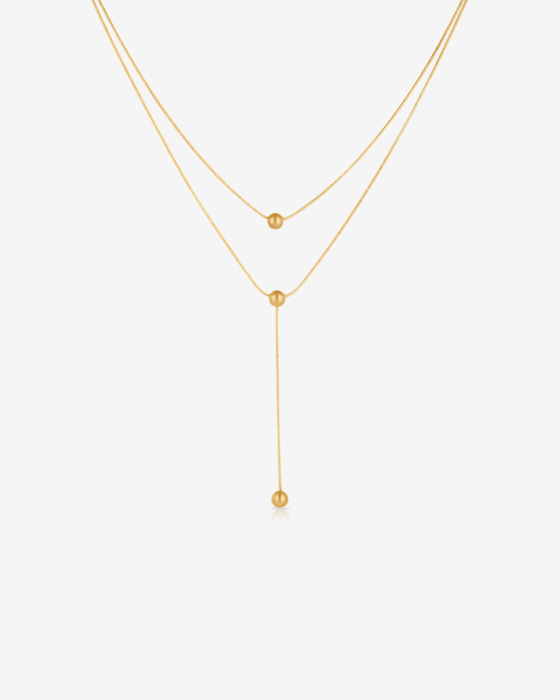 Double-strand 18K gold plated necklace with layered chains and polished ball pendants, delicate and modern for everyday or statement wear.