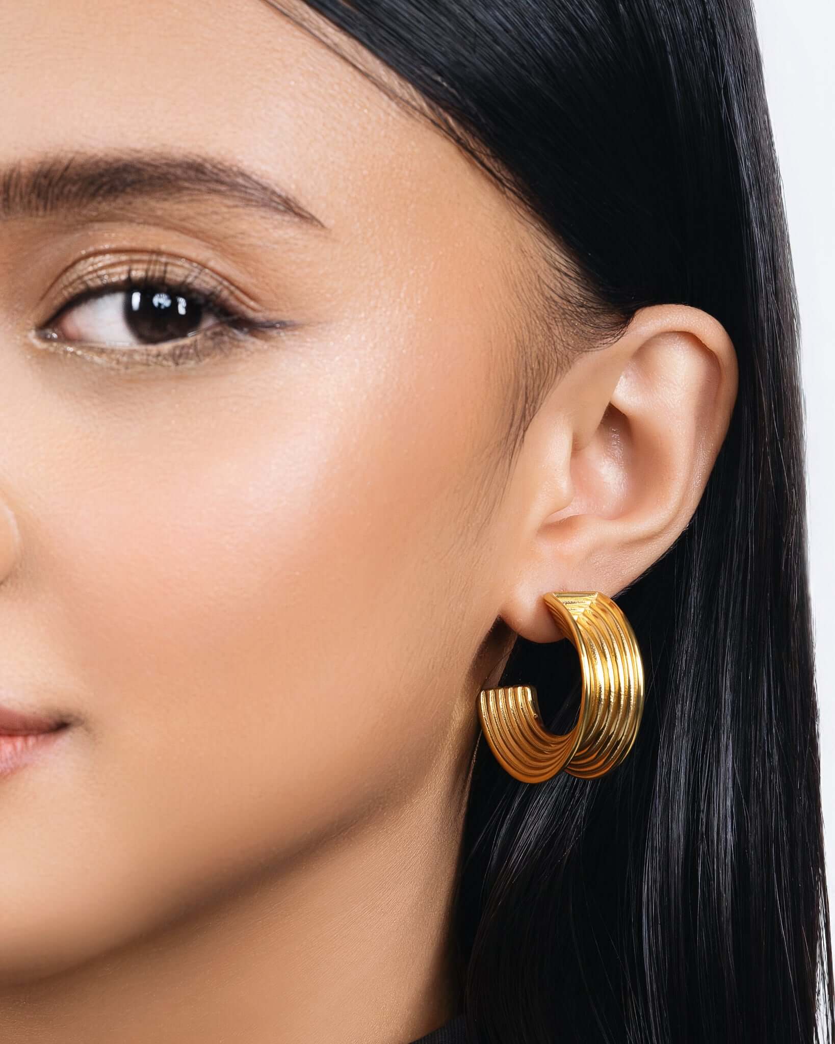 Chunky ribbed hoop earrings in gold finish, bold textured hoop earrings for women, modern statement hoops, layered ribbed design jewelry, trendy chunky gold earrings for everyday wear or elevated styling