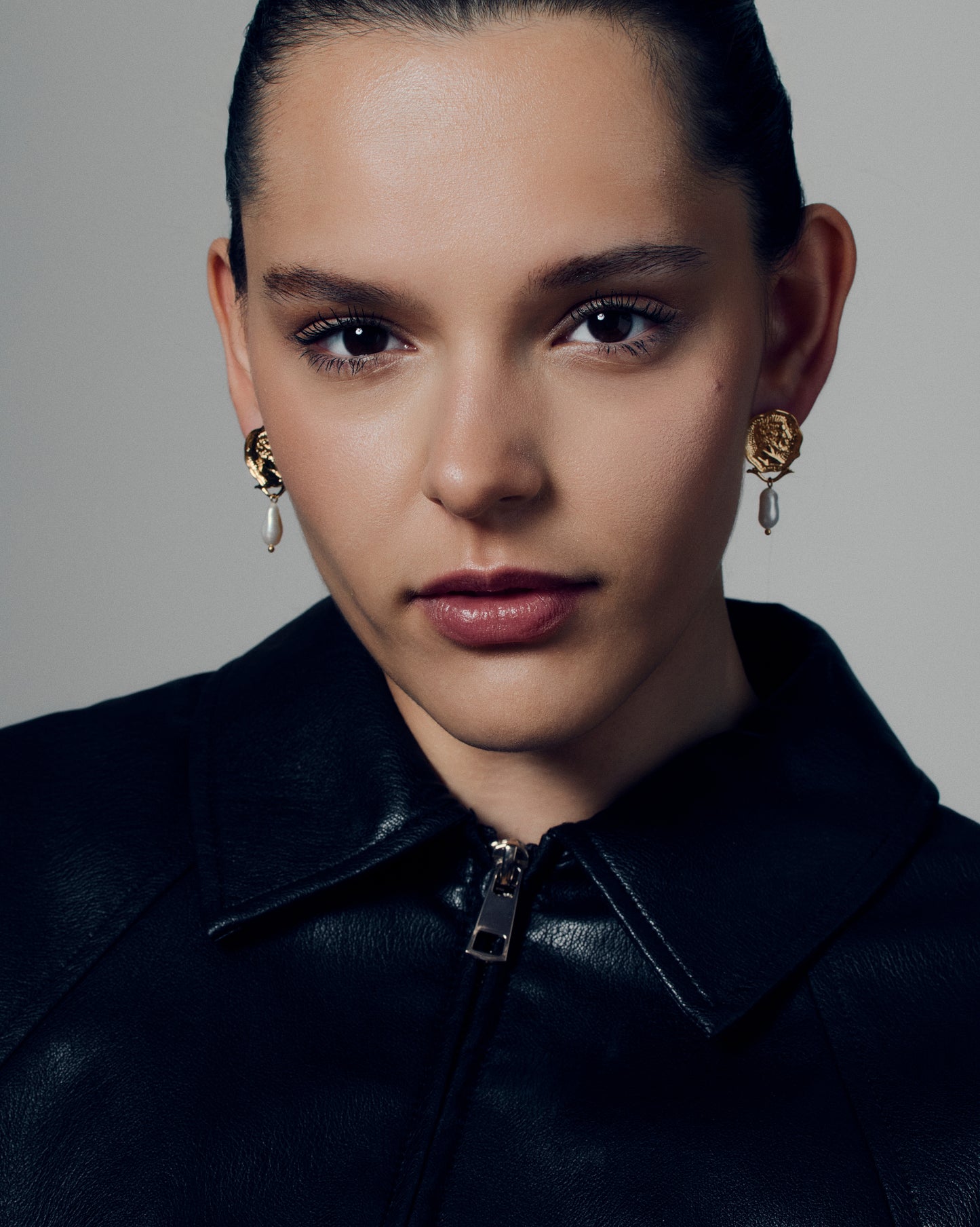 Gold coin pearl drop earrings featuring embossed medallion faces paired with natural baroque-style pearls. These sculptural statement earrings combine vintage inspiration with modern craftsmanship, offering a timeless yet bold look. Perfect for elevating everyday or occasion outfits with a touch of classic gold elegance.